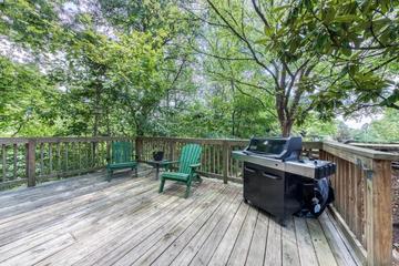 Smokies cabin rental's large deck with seating and gas grill.